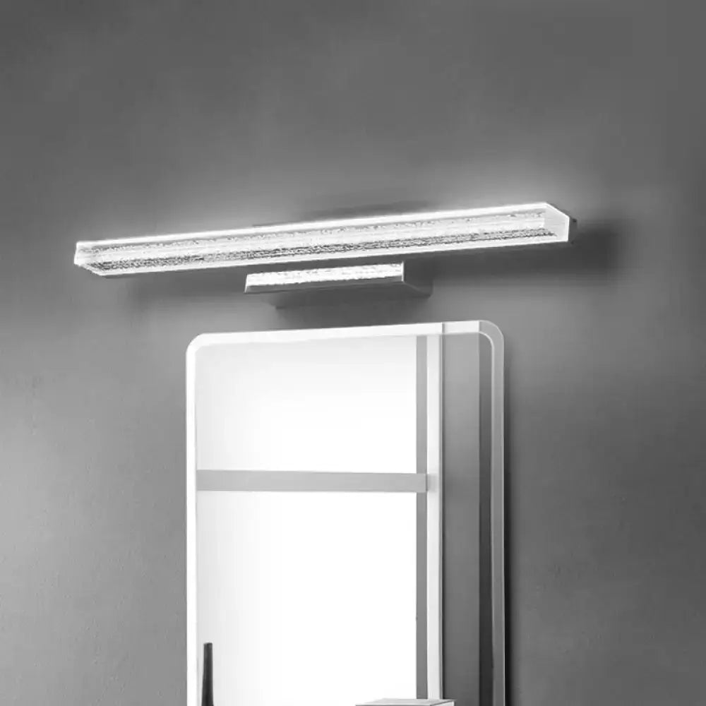 Modern silver wall mounted vanity sconce with textured crystal-encrusted acrylic shade above a bathroom mirror