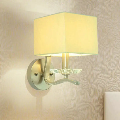 Modern brushed nickel bedside wall lamp with crystal features a cube bedside wall design with a beige fabric shade