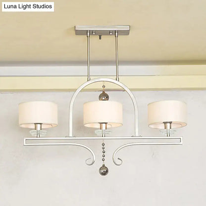 Silver-toned metal island pendant light with three cream fabric shades and crystal glass bead accents for dining room