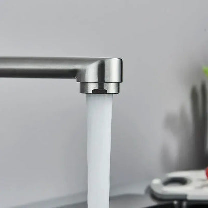 A sleek modern brushed nickel kitchen faucet wall mounted single lever mixer with a steady stream of clear water