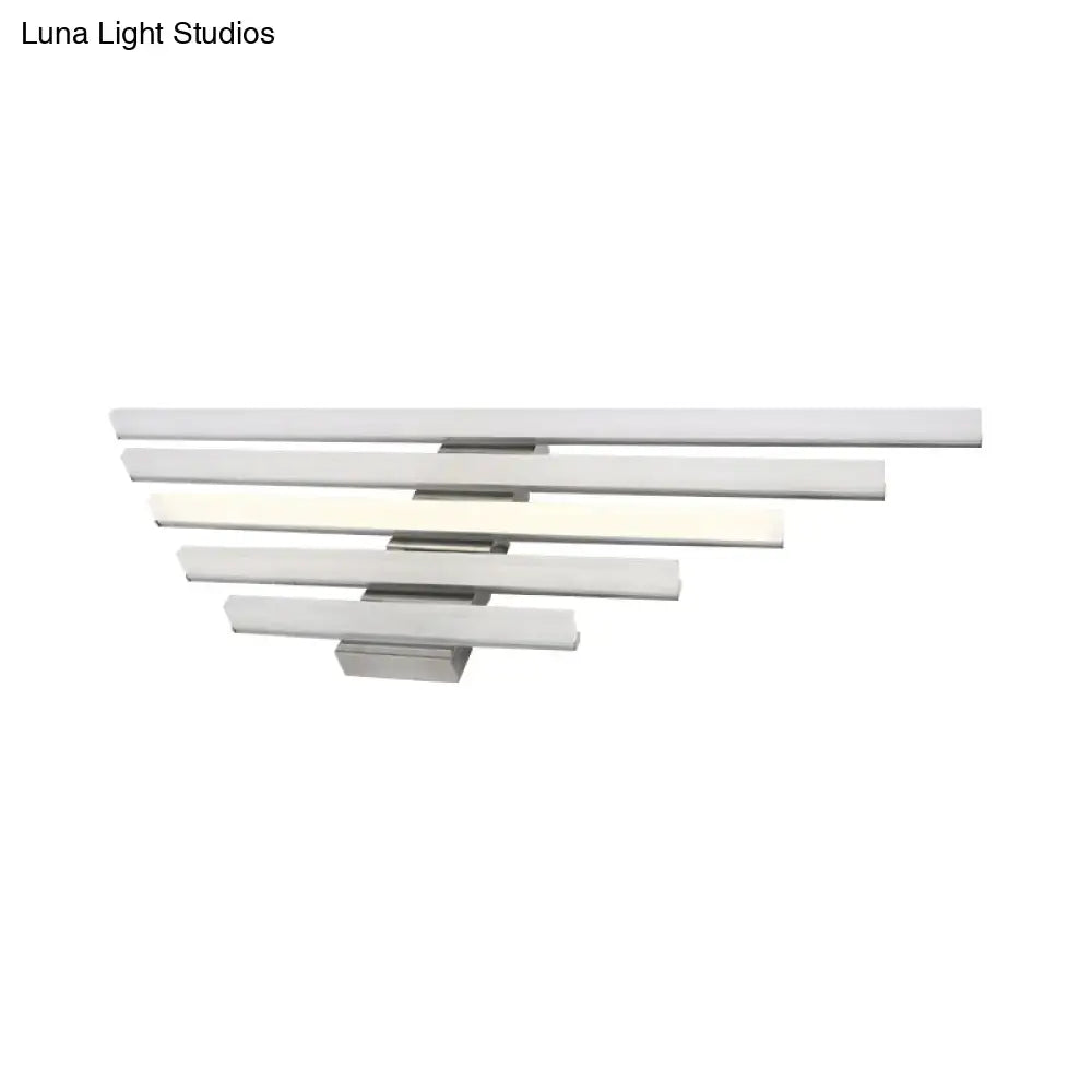 Modern brushed nickel led wall light fixture with four frosted glass bars emitting soft white glow for bathroom vanity