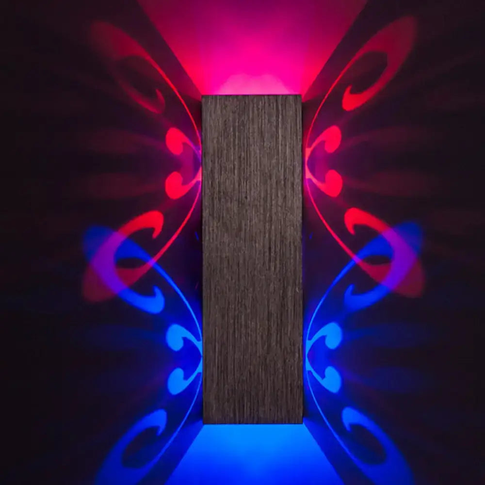 Modern brushed silver butterfly design dark wood wall sconce with bulb base casting red and blue light patterns