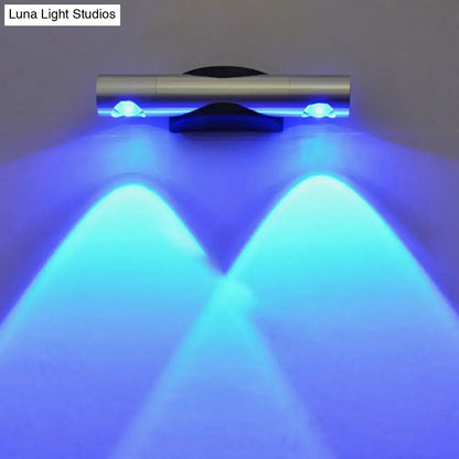 Modern brushed silver led light bedroom sconce with pink accents projecting two blue led beams downward with maximum bulb wattage