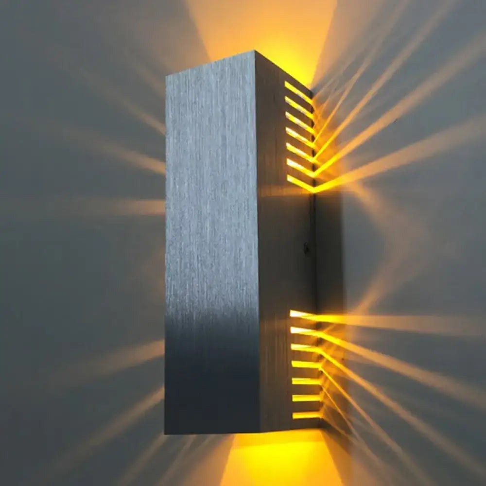 Modern rectangular wall light with brushed silver finish and warm white light emitting radiant beams for bedroom use