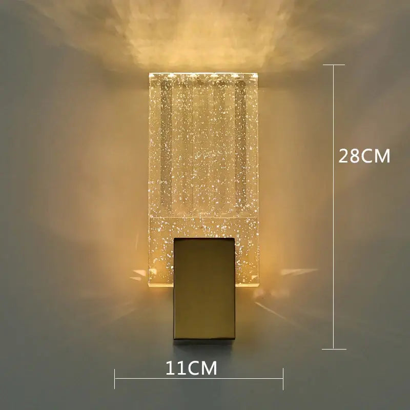 A modern rectangular wall sconce with a golden base and decorbites bubble crystal LED body for bathroom mirrors
