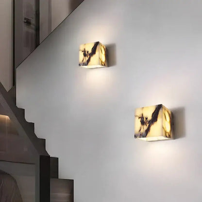 Two polished onyx square wall lights with warm creamy yellow alabaster base and dark veining from decorbites bulgari stone led collection