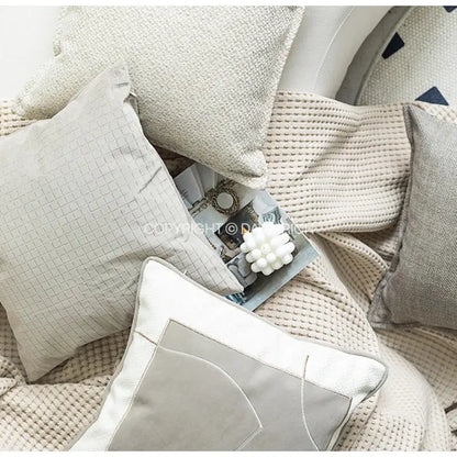 Beige textured throw pillow with subtle grid pattern and white piping featuring decorbites cappuccino tone geometry embroidery