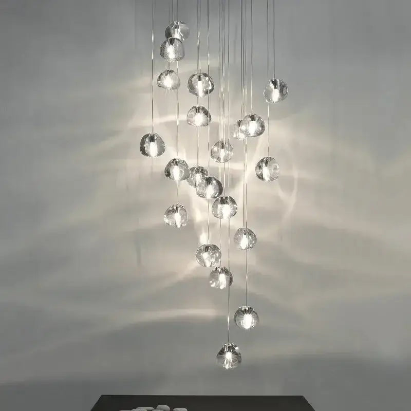 A modern cascading decorbites crystal ball chandelier with clear glass orbs and metallic chains for living room decor