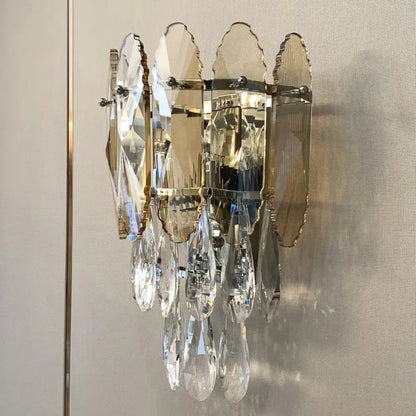 Modern champagne smoke gray crystal wall sconce with faceted leaves and teardrop pendants on polished brass hardware