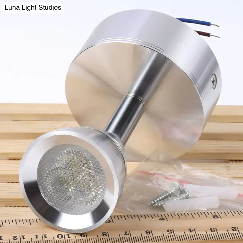 Modern chrome adjustable cylindrical led spotlight with metal shade and visible leds emitting white light for bedroom use