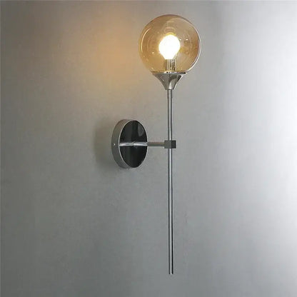 A sleek modern chrome wall lamp featuring an amber glass ball for stylish living room lighting decorbites wall lamps