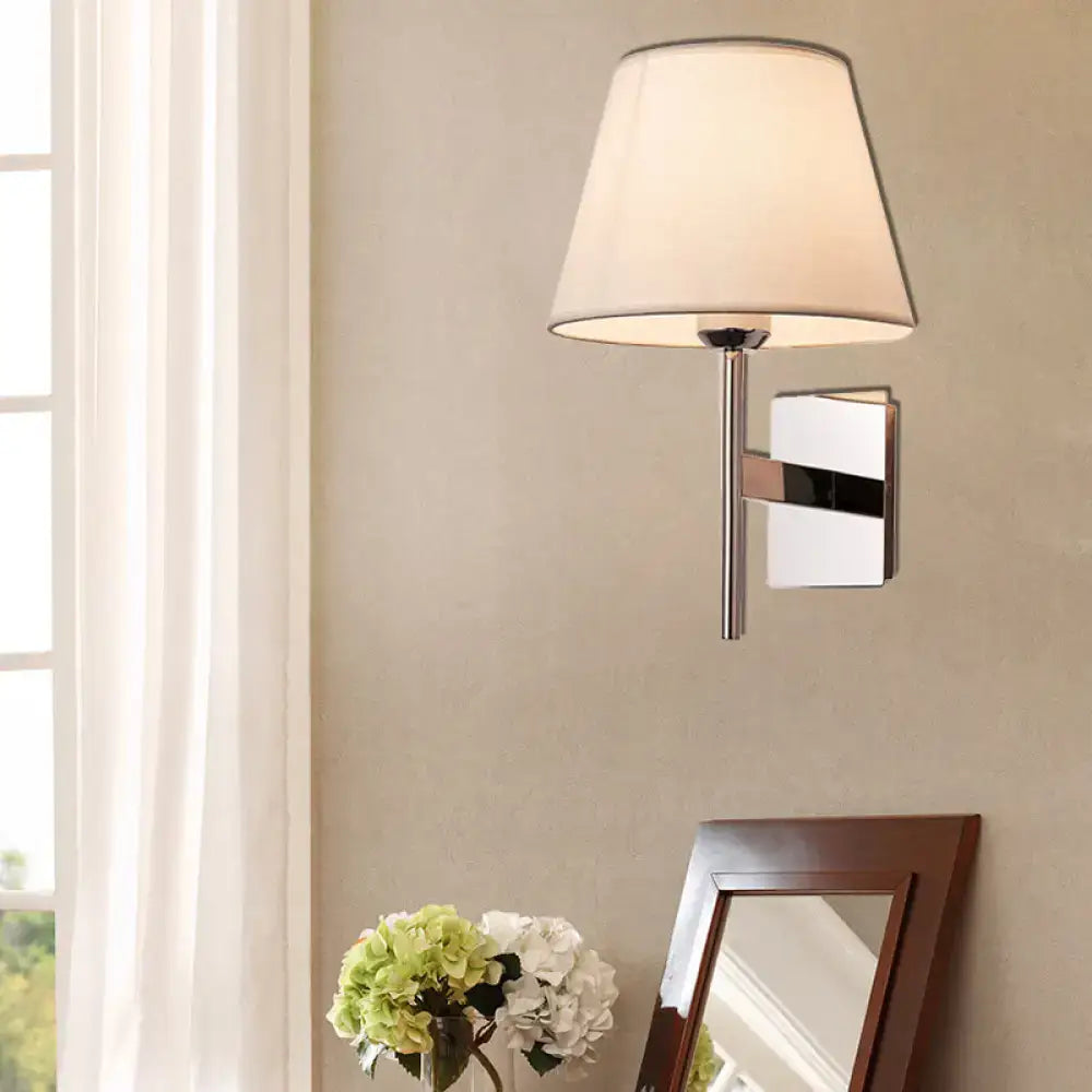 Modern chrome and beige fabric cone wall light with a soft fabric shade designed for bedroom use