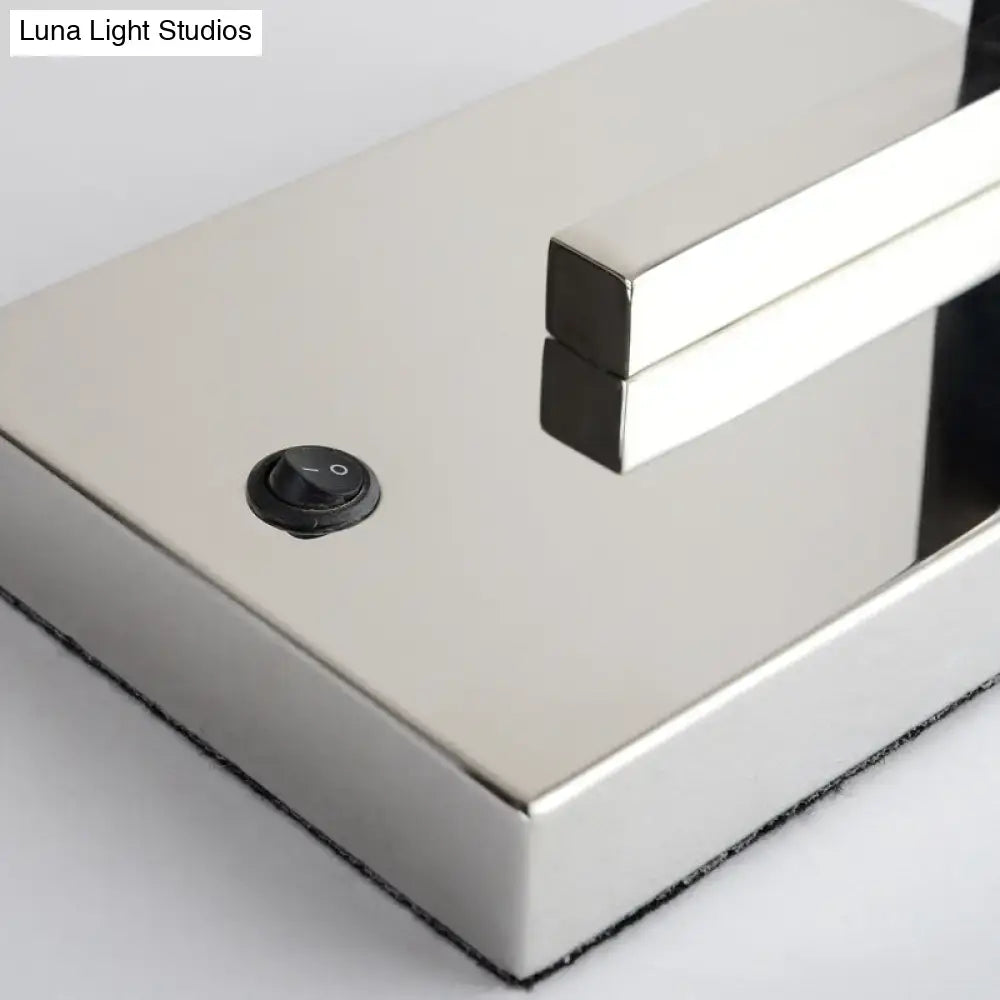 A modern chrome and beige fabric led wall sconce with a sleek rectangular table lamp design for living room use