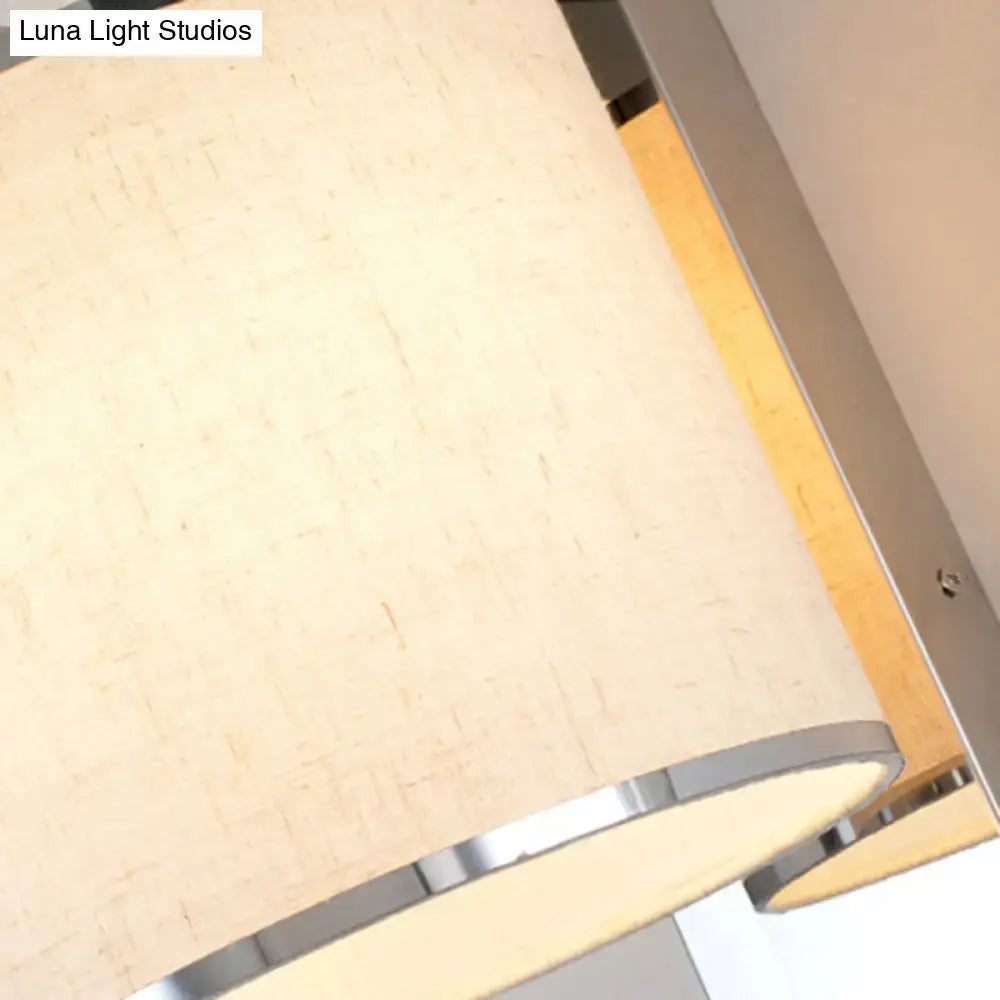 Beige textured fabric lampshade with sleek chrome rim on modern LED living room wall sconce light fixture
