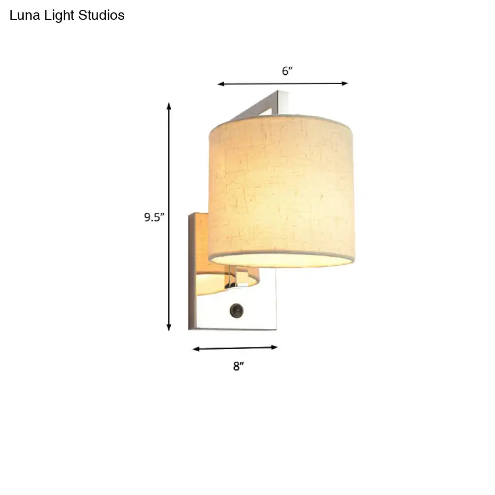 Cream-colored fabric cylindrical lampshade on modern chrome wall sconce for living room led lighting