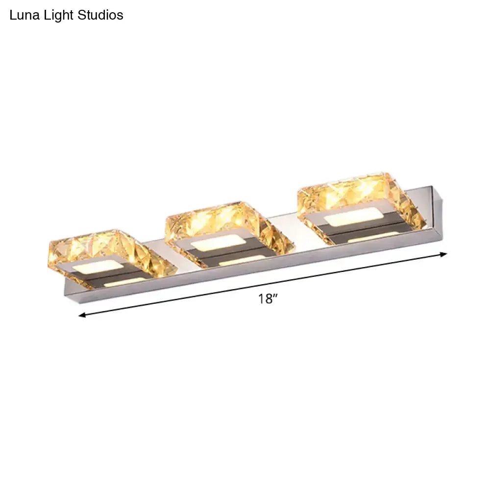 Modern chrome and gold crystal vanity sconce with three illuminated amber crystal accents on sleek stainless steel base