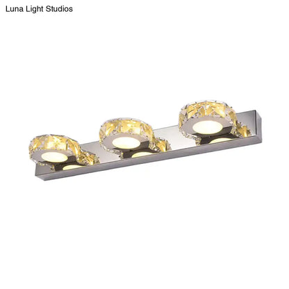 Modern chrome and gold crystal vanity sconce with three faceted crystal accents for bathroom lighting in stainless steel