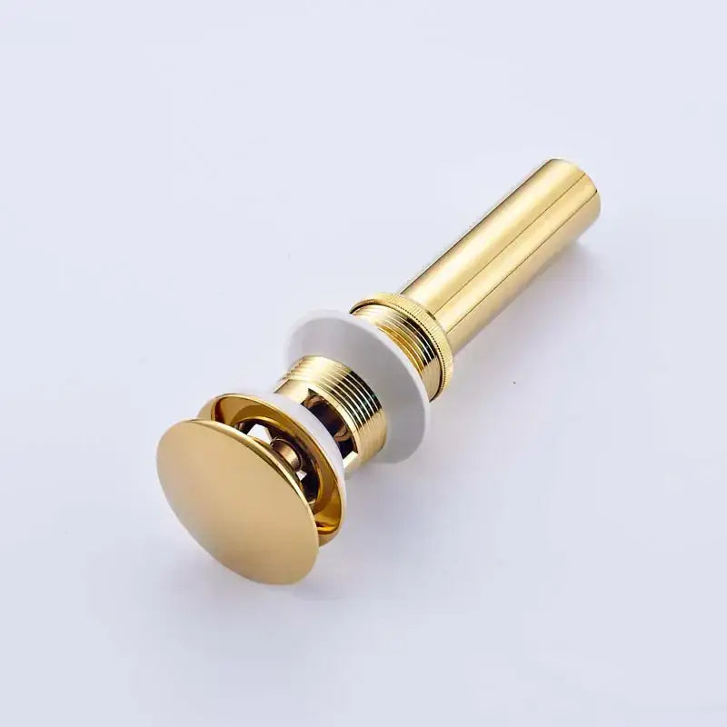 Gold-colored modern chrome and gold bathroom sink pop stopper with sleek cylindrical design and polished metallic finish