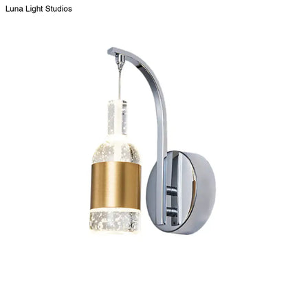 Modern chrome and gold wall sconce with seedy crystal accents and bottle-shaped glass globe for dining room lighting