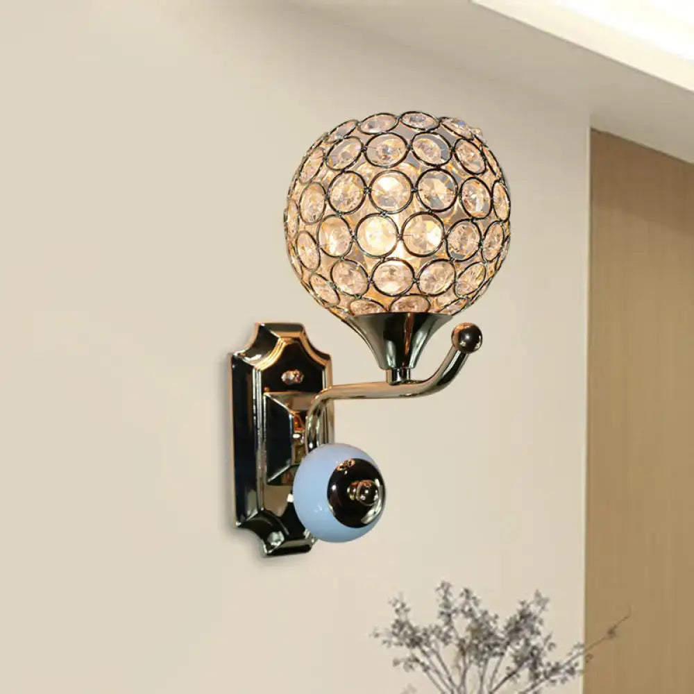 Modern chrome bedroom wall sconce with a spherical crystal globe and a light blue ceramic knob