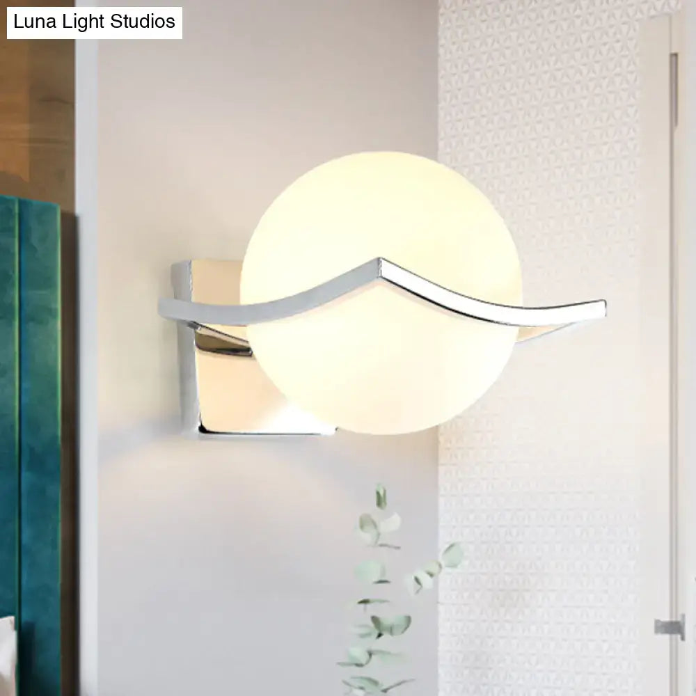 Modern chrome wall sconce with matte white glass spherical shade and sleek metal arms for bedroom lighting