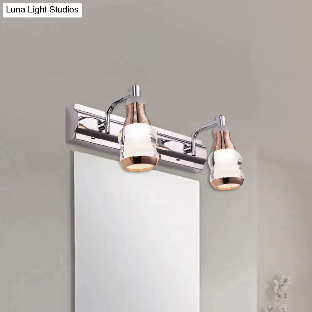 Modern two-light vanity wall light with polished chrome and rose gold accents and clear glass shades product includes