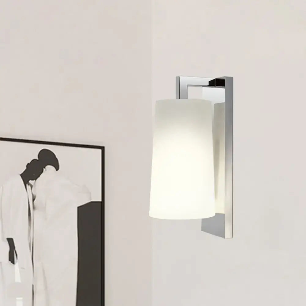 Modern chrome wall lamp with frosted white cylindrical glass shade and compact fixture height for bedroom use