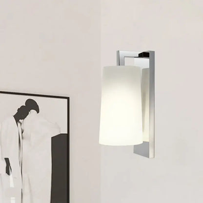 Modern chrome wall lamp with frosted white cylindrical glass shade and compact fixture height for bedroom use