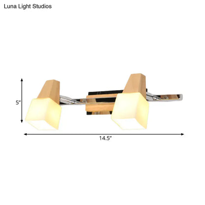 Modern chrome and wood cube vanity light fixture with warm geometric acrylic shades for bathroom lighting
