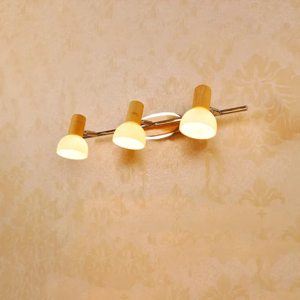 Modern three-light wall sconce with warm white glass dome shades and a sleek chrome and wood frame for bathroom vanity