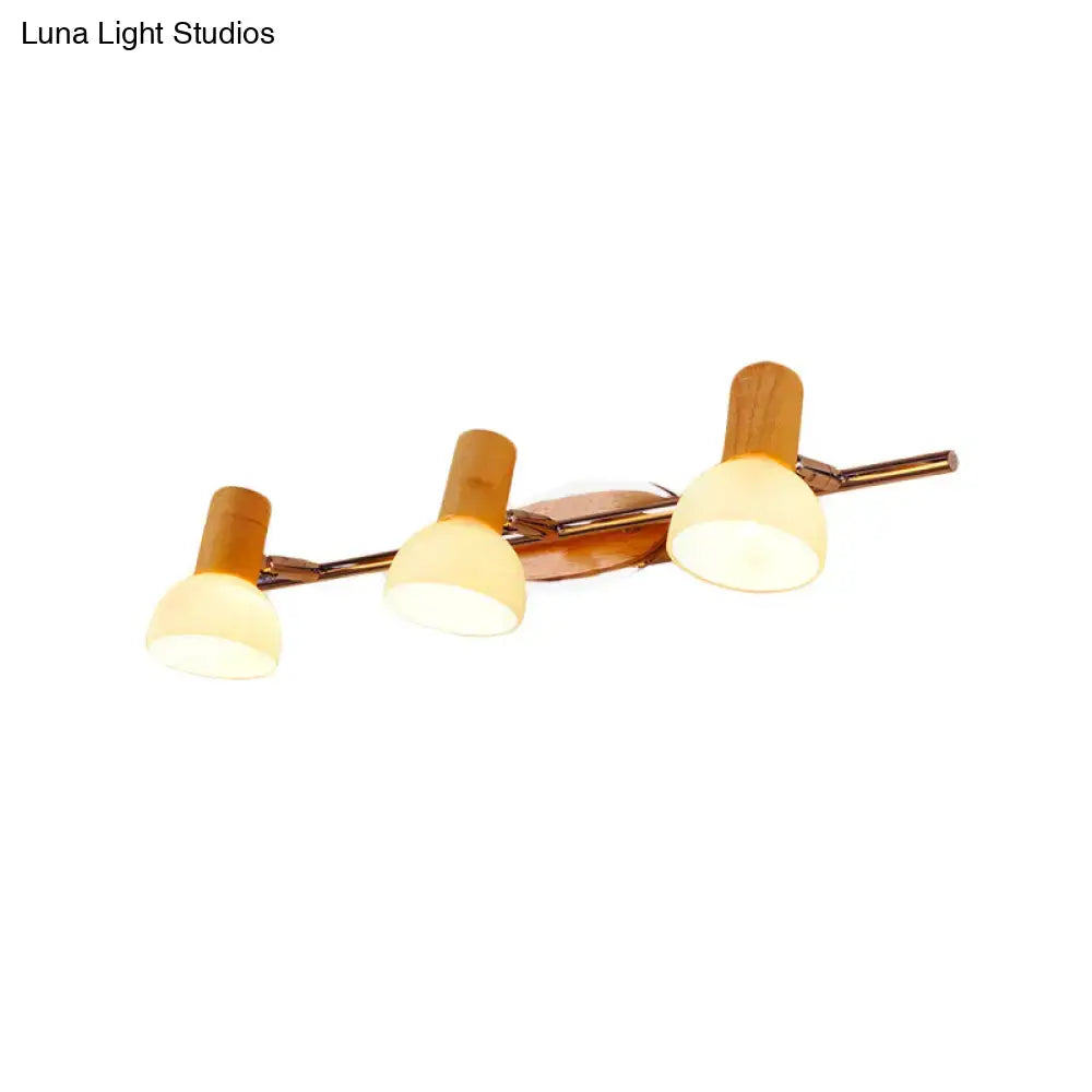 Modern three-light chrome and bamboo vanity light with warm white glass dome shades for bathroom use