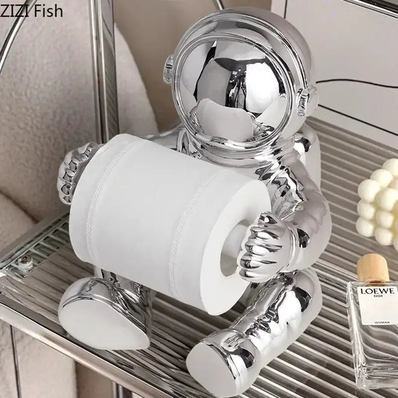 Modern chrome astronaut tissue box holder in shiny chrome metal holding a roll of white tissue for living room use