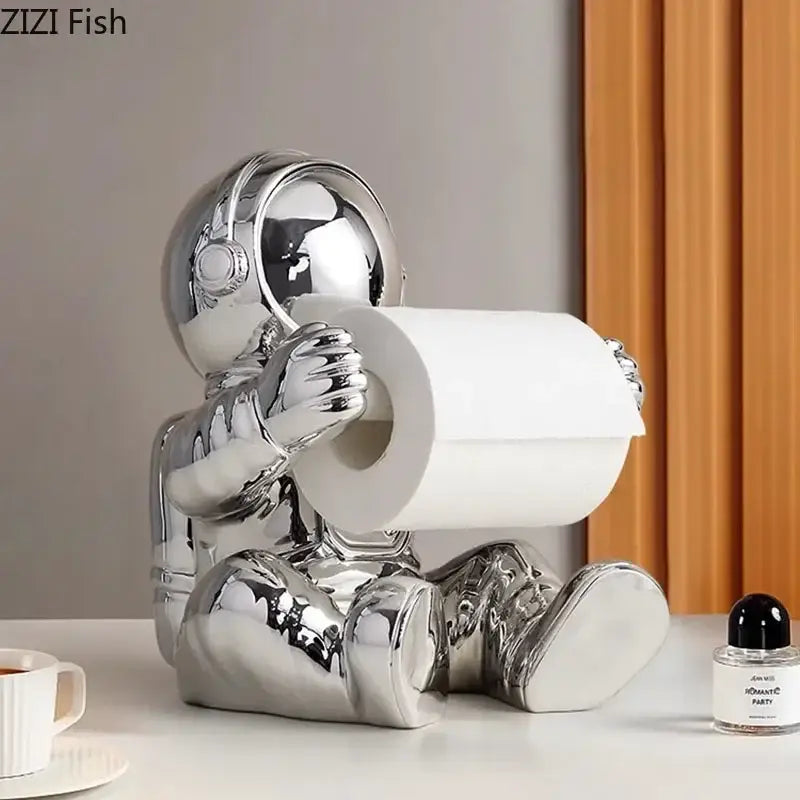 Shiny chrome astronaut tissue box figurine holding roll of toilet paper for modern living room decor