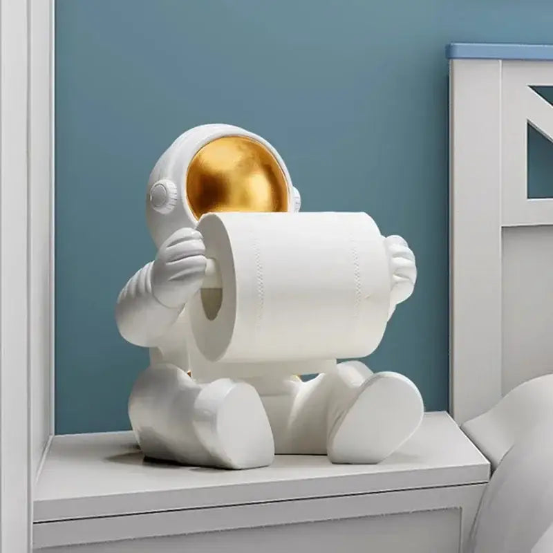 White astronaut tissue box figurine with gold visor holding roll of toilet paper modern chrome design for living room