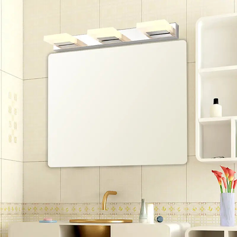 White rectangular bathroom mirror with modern chrome vanity light featuring acrylic shade and bulb included above it