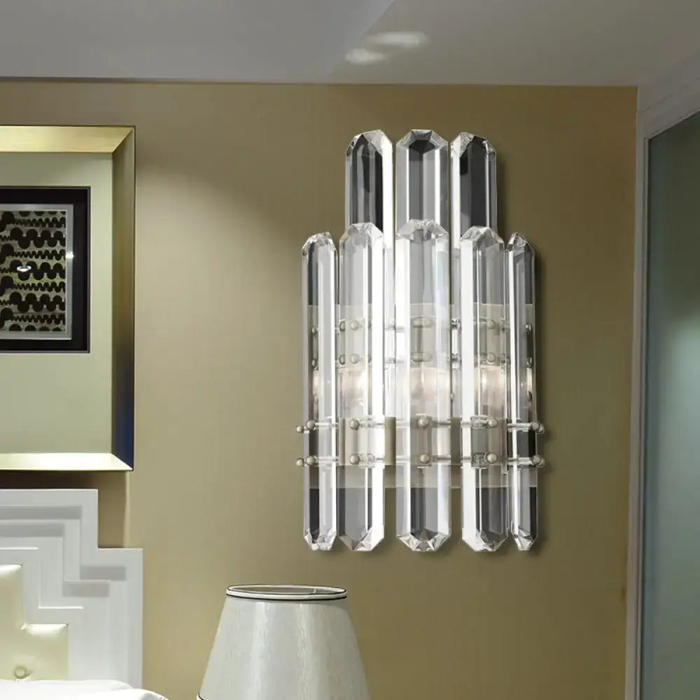 Modern chrome and black direct wired electric wall sconce with clear crystal faceted rods and metallic accents for bedroom use