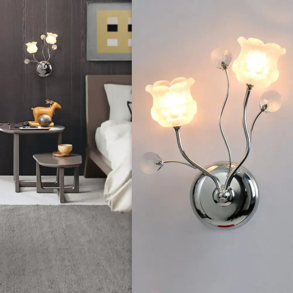 Modern chrome bloom shade wall sconce with three illuminated translucent glass flower shades and clear crystal accents