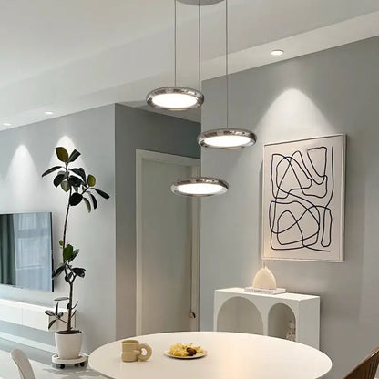 Three modern chrome circular dining pendant led lights with sleek frames and soft white illumination for kitchen decorbites circular dining use