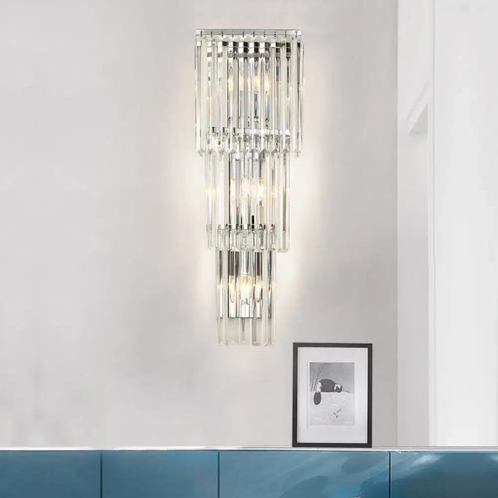 Modern chrome wall sconce light with clear glass shade featuring cascading crystal rods for bedroom lighting