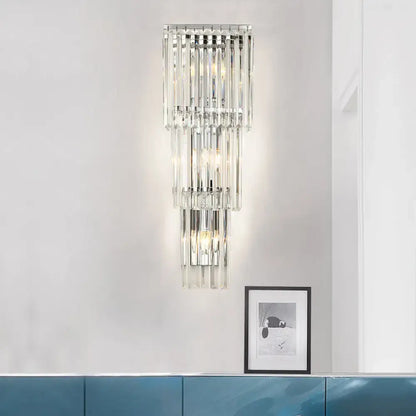 Modern chrome wall sconce light with clear glass shade featuring cascading crystal rods for bedroom lighting