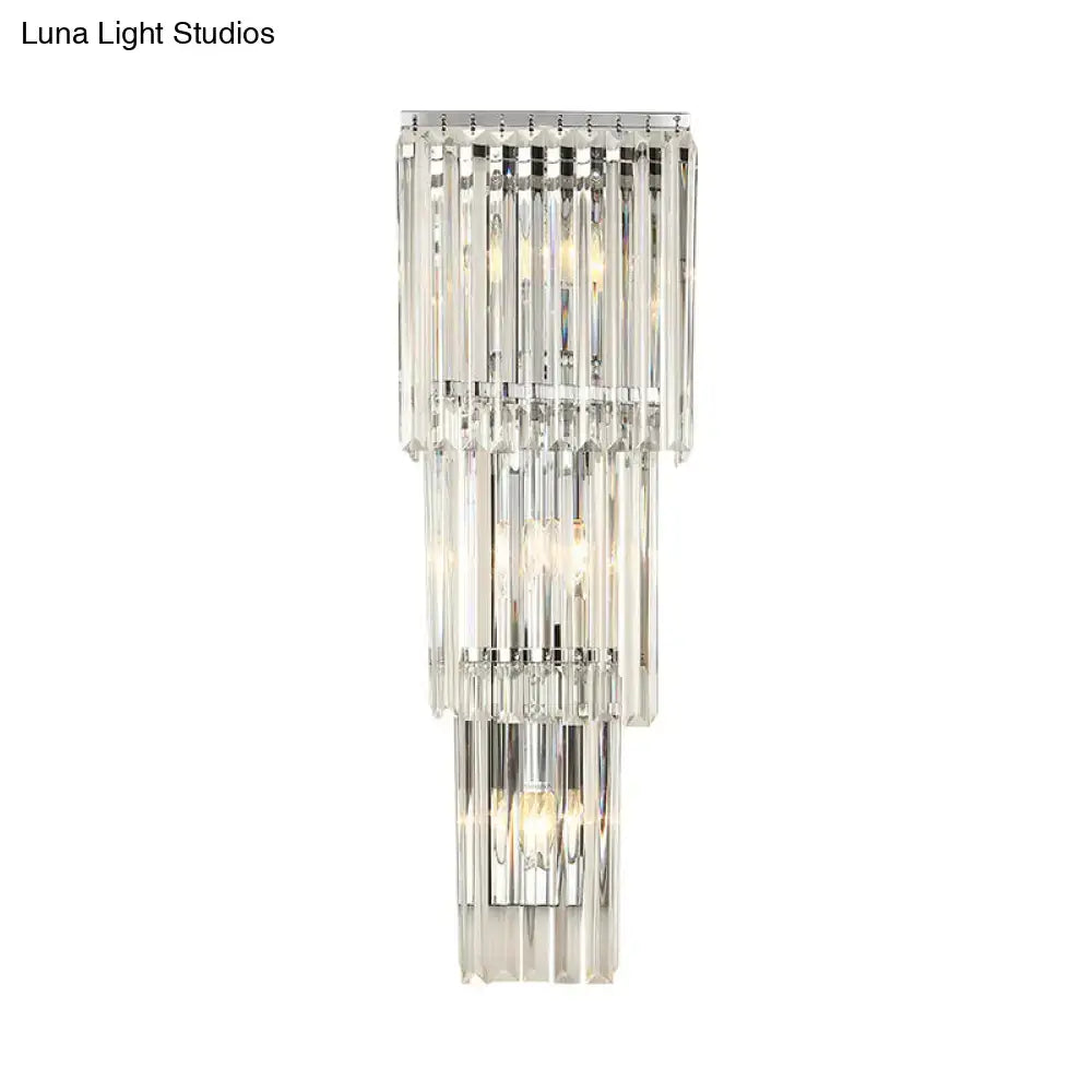 Modern chrome wall sconce light with cascading clear glass shade and faceted crystal rods for bedroom illumination