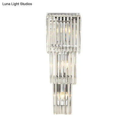 Modern chrome wall sconce light with cascading clear glass shade and faceted crystal rods for bedroom illumination