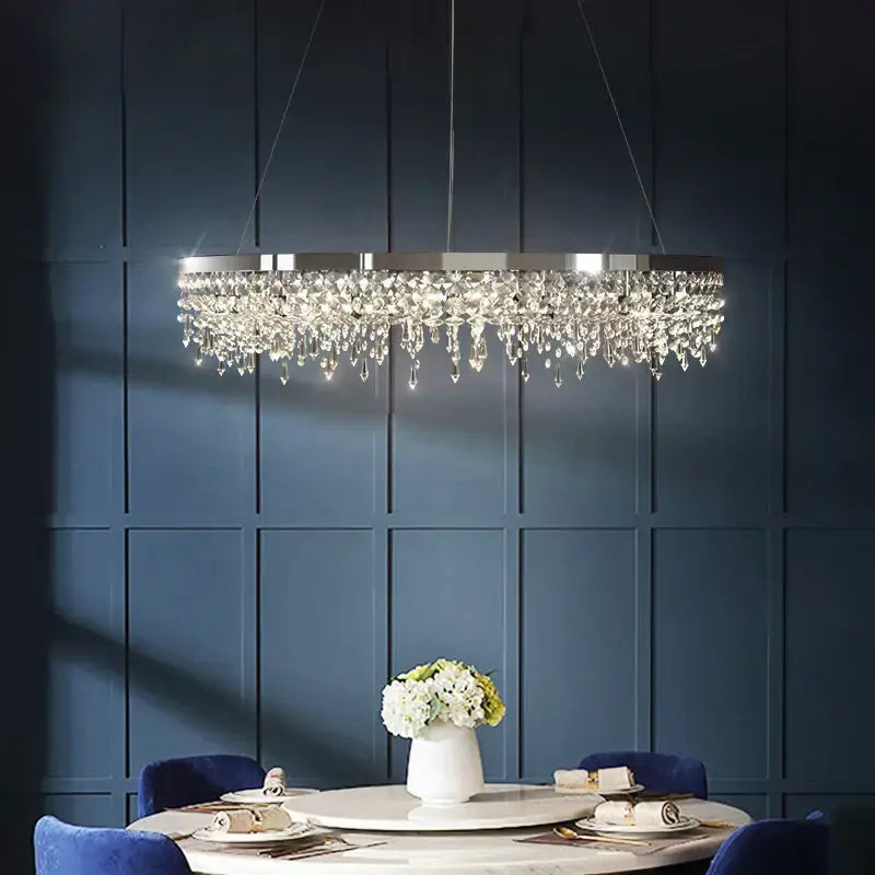 A modern chrome decorbites crystal circle led chandelier with sleek metallic frame and cascading crystal droplets for living room decor