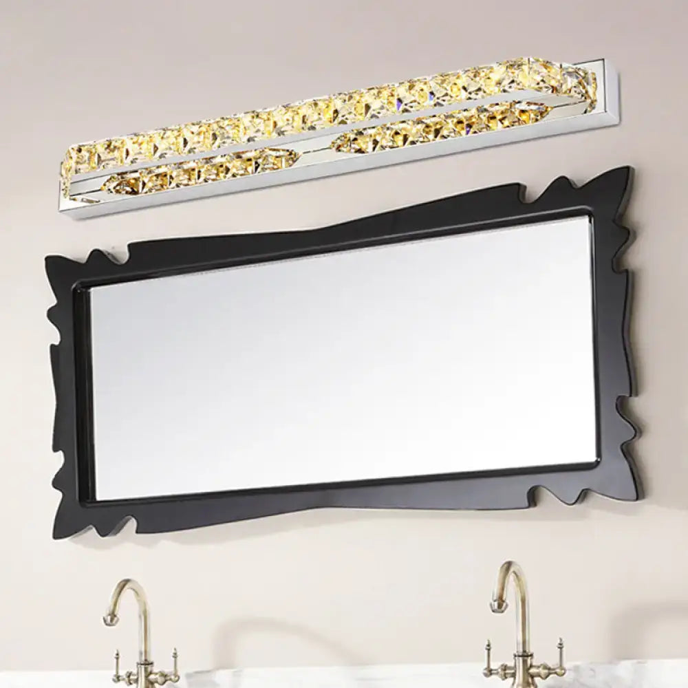 A sleek modern chrome wall light fixture with crystal encrusted golden accents and compact fixture height for bathroom use