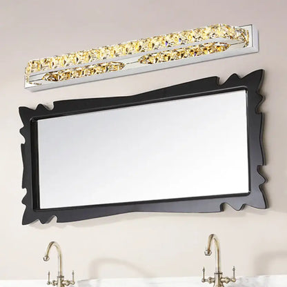 A sleek modern chrome wall light fixture with crystal encrusted golden accents and compact fixture height for bathroom use