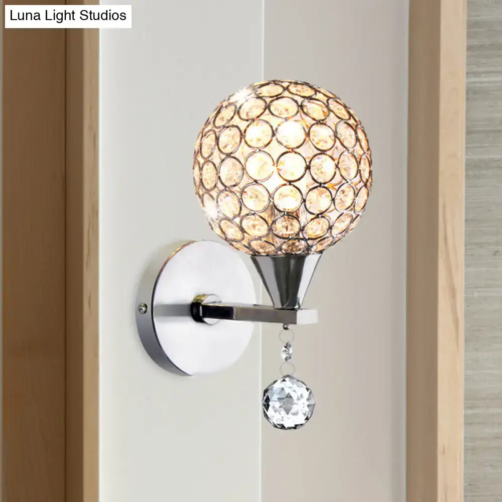 Modern chrome crystal encrusted wall light featuring a spherical globe and faceted crystal pendant for bedroom sconce use