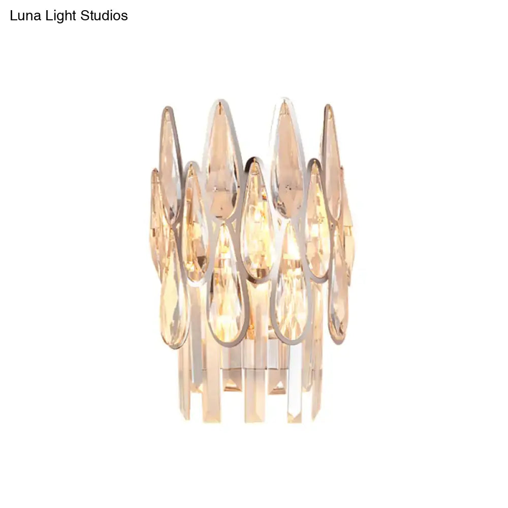 A modern chrome crystal teardrop wall sconce with warm golden glow for living room 110v-120v lighting