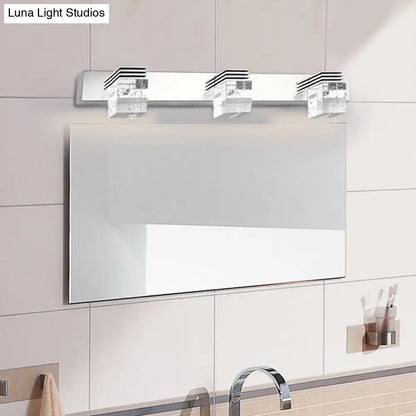 Modern chrome crystal vanity light fixture with three rectangular crystal-like fixtures for bathroom use
