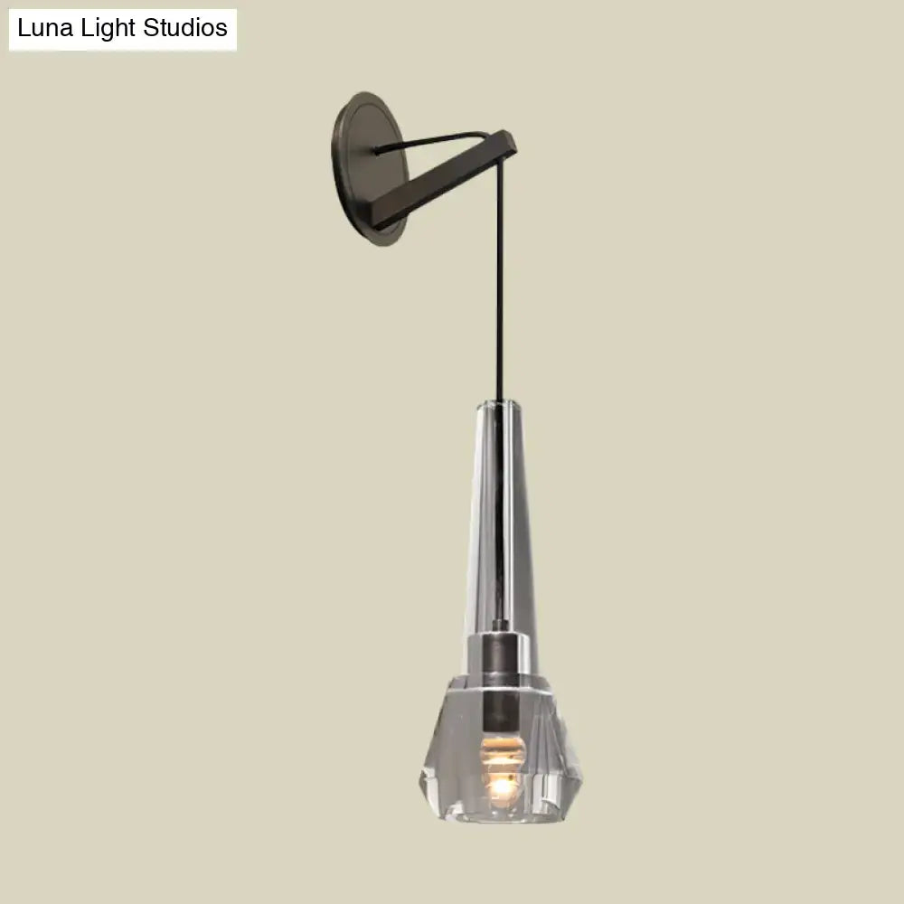 Modern chrome crystal wall lamp with sleek black metal bracket clear faceted shade and illuminated bulb with dangling cord