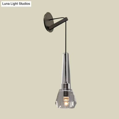Modern chrome crystal wall lamp with sleek black metal bracket clear faceted shade and illuminated bulb with dangling cord